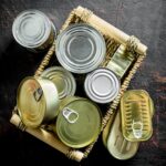 Closed cans of canned food on tray.